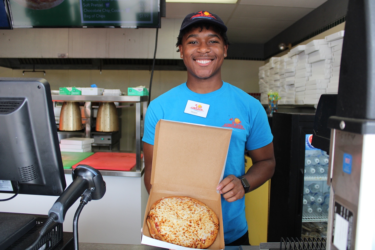 Worker holding pizza